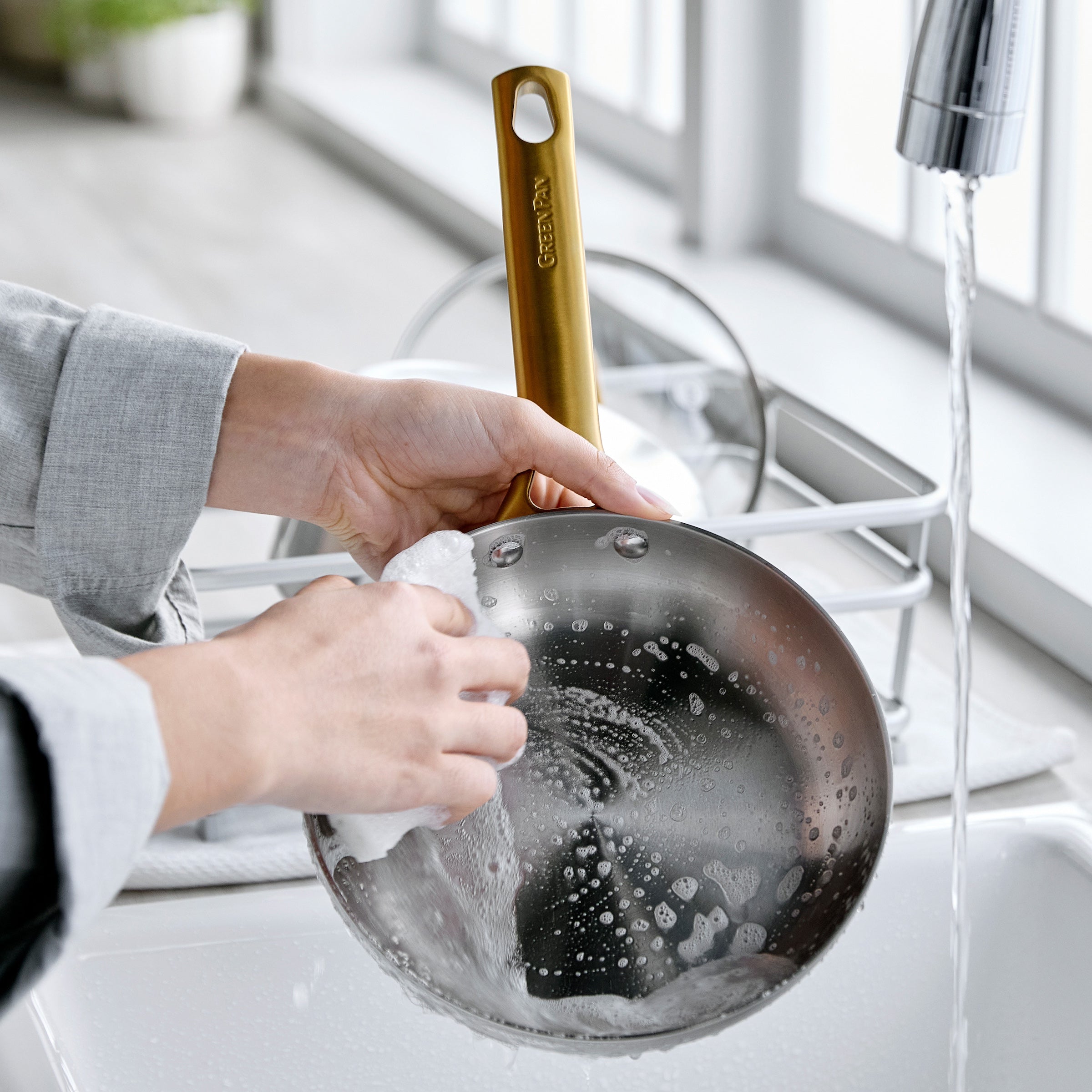 Stainless steel frypan being hand washed